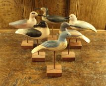 A collection of six painted wooden decoy type bird ornaments depicting ducks and waders,