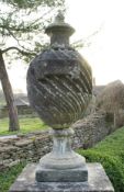 A carved reconstituted stone garden urn or finial of wrythen stop fluted form,