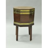A late George III mahogany and brass bound cellerette or wine cooler of octagonal form with brass