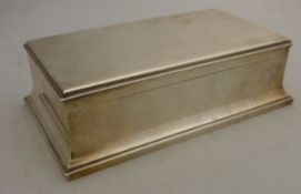 A George V silver table mounted cigarette box of rectangular form on flared stepped base (by