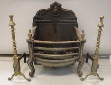 A pair of early 20th Century brass mounted fire dogs together with a fire basket,