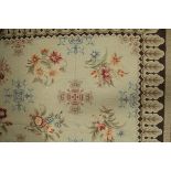 An Aubusson style rug the central panel set with floral sprays on a mushroom ground within a
