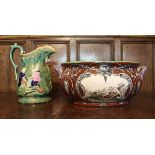 A Victorian majolica George Jones style toilet jug depicting figures by fire,