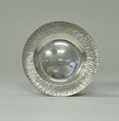 A mid 20th Century silver dish, the flared rim of bark texture (by Gerald Benney, London 1970),