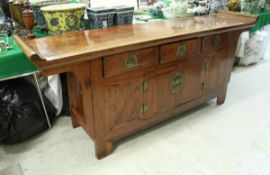 A Chinese hardwood side cabinet the plain top with scroll ends over three drawers and two cupboard