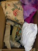 A box containing assorted scrap material, needlework,