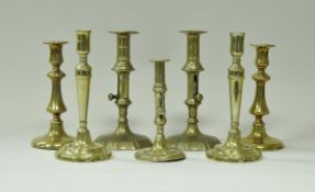 A collection of brass candlesticks to include a pair of petal based ejector candlesticks,