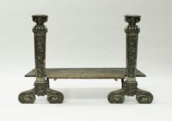 A pair of heavy cast iron andirons in the Arts and Crafts manner with horned head finials over