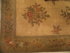 An Aubusson style rug the central panel set with floral sprays on a neutral ground within a stepped