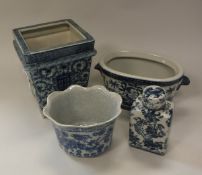 A pair of modern Chinese style blue and white square tapering jardiniers raised on bracket feet,