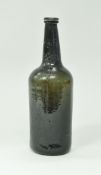 An 18th Century dark green/black glass wine bottle,