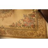 An Aubusson style rug the central panel set with floral decorated medallion on a cream ground with