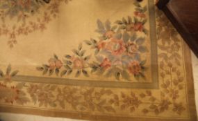 An Aubusson style rug the central panel set with floral decorated medallion on a cream ground with