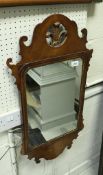 A 20th Century walnut framed fretwork carved wall mirror in the Georgian manner with fleur de lys