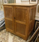An early to mid 20th Century oak livery cupboard with two doors enclosing six linen shelves
