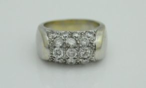 An 18 carat white gold dress ring with central diamond-studded barrel decoration,
