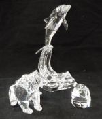 A Swarovski Crystal Society dolphin riding wave together with a Swarovski Crystal Society bear sat