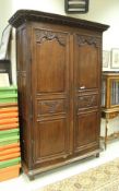 A 19th Century French oak armoire with carved decoration to the fielded panel doors