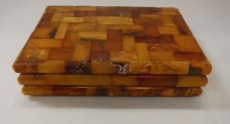 A Baltic amber mounted cigarette box of tiled form,