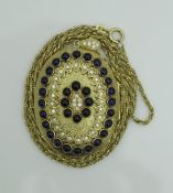 An 18 carat gold diamond and cabochon cut sapphire locket of oval form on an 18 carat gold chain,