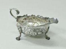 A George II silver sauceboat with later embossed floral decoration and initialled "A.R.