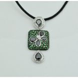 An 18 carat gold designer pendant set with tsavorite black diamonds and white diamonds,