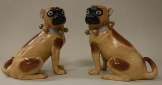 A pair of Carl Thieme potschappel brown spotted pug figures with ribbon and bell collars bearing