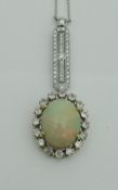 A yellow and white gold pendant set with large central opal surrounded by sixteen brilliant cut