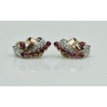 A pair of 18 carat gold mounted ruby and diamond set clip-on earrings in a scroll form, 8.7 g, 2.