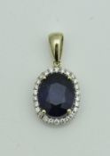 A 14 carat gold mounted sapphire and diamond pendant,