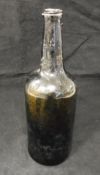 An 18th Century dark green/black glass wine bottle,