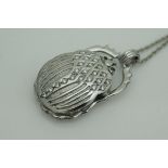 An unmarked 18 carat white gold pendant in the form of a scarrab beetle with diamond studded back