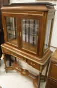 A French mahogany vitrine with marble top over a glazed two-door cabinet and three drawers in the