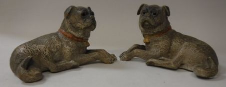 A pair of Austrian painted terracotta figures of recumbant pugs