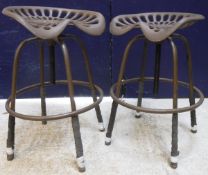 A pair of modern painted cast iron adjustable tractor seat stools