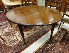 A 19th Century mahogany oval drop-leaf dining table on turned legs to pad feet