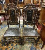 A pair of 19th Century carved oak framed hall chairs in the Carolean taste each with figural