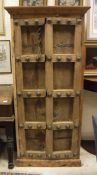 A middle eastern heavy wooden two-door cupboard with brass studded decoration