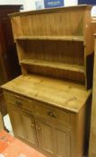 A pine dresser with two-tier plate rack over two drawers and two cupboard doors