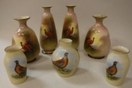 A pair of Samuel Fielding & Co Crown Devon vases decorated with cock and hen pheasant by J Coleman,