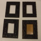 A collection of four Japanese carved teak picture frames, one decorated with bullrushes,