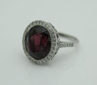 An unmarked 18 carat white gold dress ring set with large rubelite to the centre surrounded by