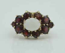 A late 20th Century 9 carat gold opal and garnet set cluster ring in the Victorian taste, size Q/R,