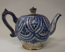 A blue and white glazed terracotta bullet shaped teapot