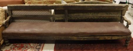 A Victorian railway type upholstered settle/bench seat with scroll arms on turned legs