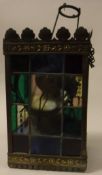 A late Victorian leaded glazed embossed brass framed hanging lantern with oil lamp light