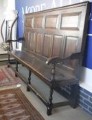 A 19th Century oak hall settle with fielded panel back and plant seat on turned legs united by
