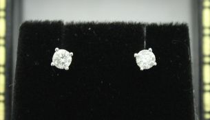 A pair of 9ct white gold and solitaire diamond stud earrings