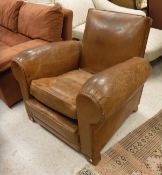 An early 20th Century brown leather upholstered scroll arm chair