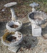 A pair of composite garden urns of low form on raised on square bases,